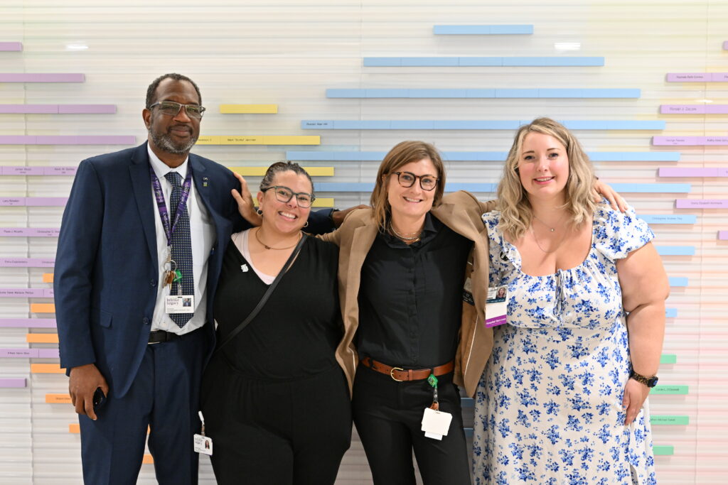 Four Infinite Legacy team members wrap arms around each other for a group picture.