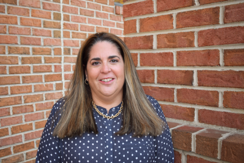 Vice President and Chief Administrative Officer, Emily Goldbloom, stands outside of Infinite Legacy's office smiling.